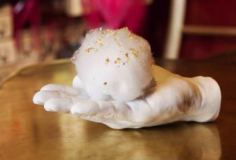 A plaster hand holds a cotton candy at é by José Andrés