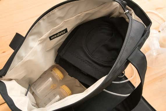 An image of the inside of the Medela pump on-the-go tote bag. The bag contains two bottles and a pumping bra.