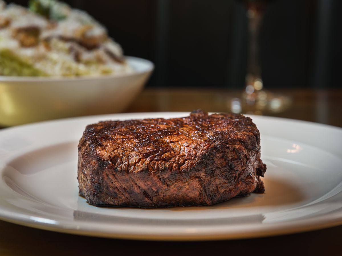 Savor the sight of a charred rump steak served beautifully on a pristine white plate.