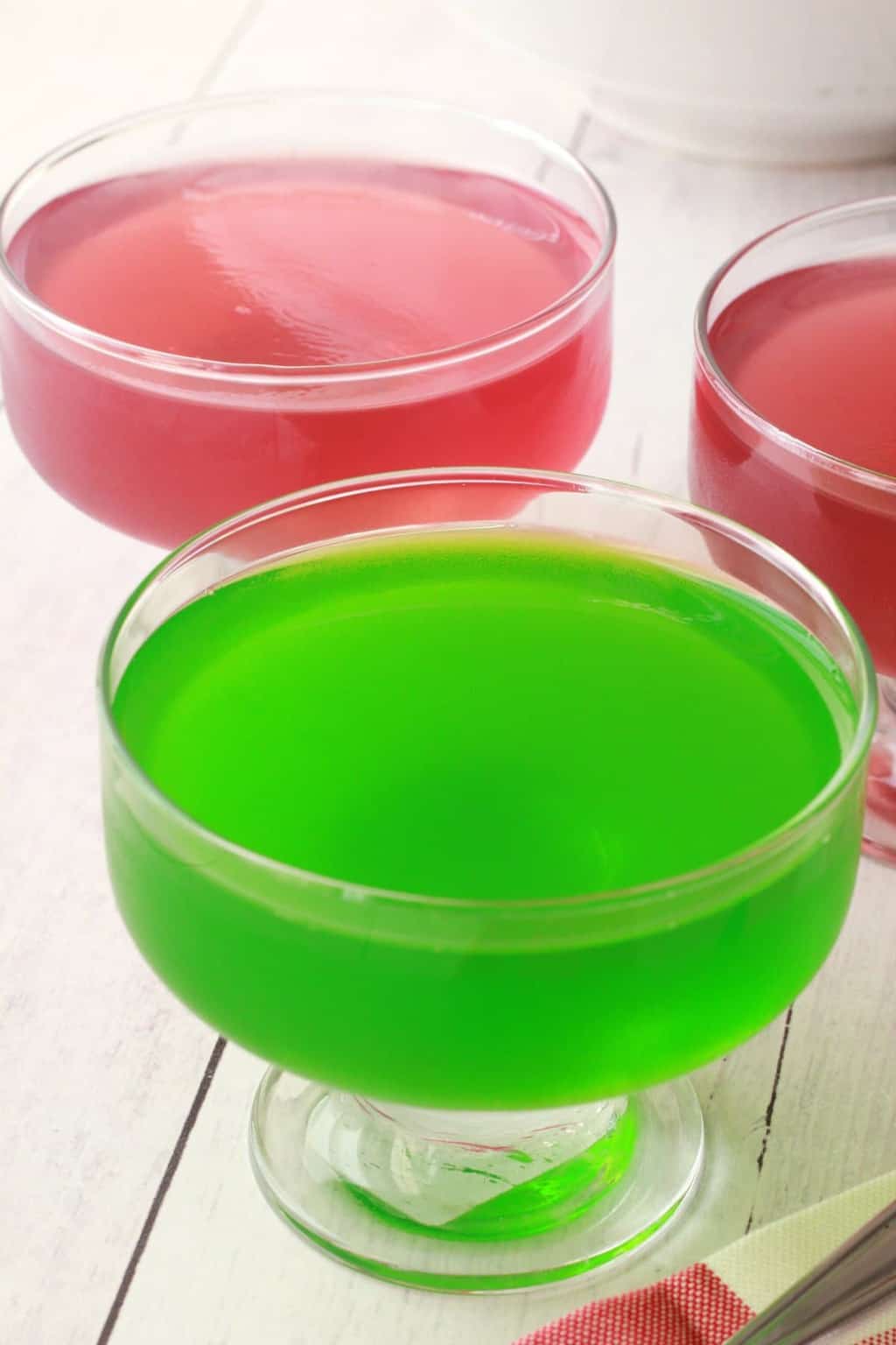 Red and green vegan jello in glass dishes.