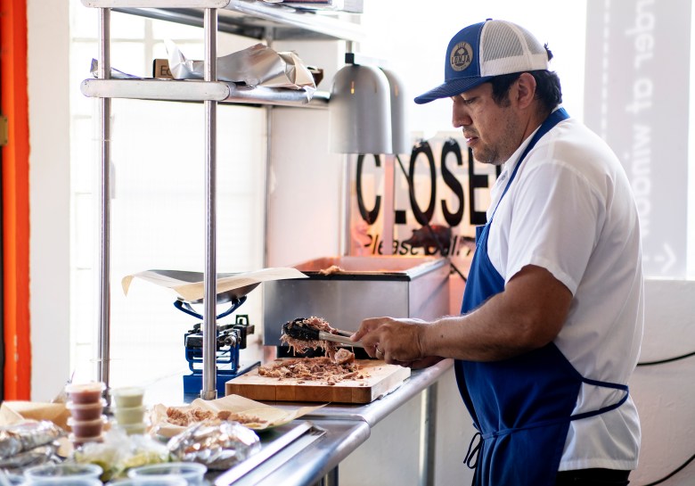 Carnitas Lonja chef Alex Paredes prepares an order of carnitas on Wednesday.