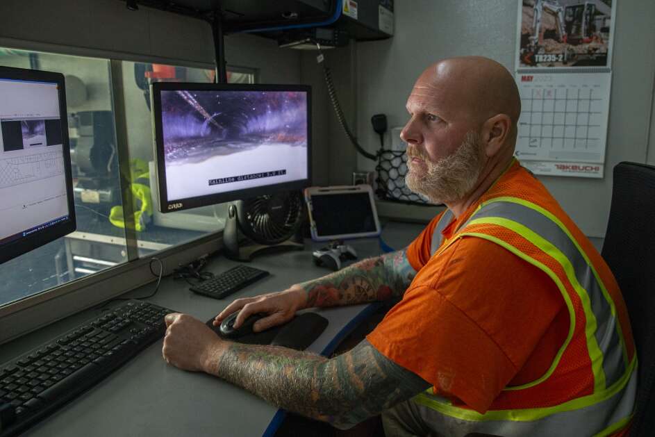 Kerrie Brown, lead televising equipment operator with the City of Cedar Rapids looks at a map of the sewer system while operating a sewer camera during a job in Cedar Rapids on May 18. (Savannah Blake/The Gazette)